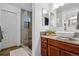 Bathroom with a walk-in shower and vanity with wood cabinets at 16278 E 105Th Way, Commerce City, CO 80022