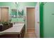 Bright bathroom with neutral tile, green painted walls and a dark wood vanity at 16278 E 105Th Way, Commerce City, CO 80022
