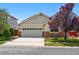 Charming two-story home with a two-car garage and stone accents, set against a backdrop of lush greenery at 16278 E 105Th Way, Commerce City, CO 80022