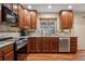 Kitchen featuring granite countertops, stainless steel appliances, and wooden cabinets at 16278 E 105Th Way, Commerce City, CO 80022
