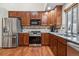 Kitchen showcasing stainless steel appliances, wooden floors, and ample cabinet space at 16278 E 105Th Way, Commerce City, CO 80022