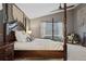 Inviting main bedroom featuring a four-poster bed and warm natural light at 16278 E 105Th Way, Commerce City, CO 80022