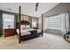 Spacious main bedroom with a four-poster bed, ceiling fan, and neutral color palette at 16278 E 105Th Way, Commerce City, CO 80022