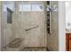 Luxurious walk-in shower featuring tile surround, a bench, and multiple shower heads for a spa-like experience at 16278 E 105Th Way, Commerce City, CO 80022