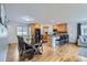 Open-concept living space with hardwood floors adjacent to dining area and a kitchen island at 3150 W Stanford Ave, Englewood, CO 80110