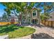 Beautiful backyard view showcasing mature trees, landscaped lawn, and a stone patio, enhancing outdoor living at 1774 Brookside Dr, Highlands Ranch, CO 80126