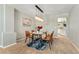 Open dining room with modern chandelier and seating for four; view to kitchen at 1774 Brookside Dr, Highlands Ranch, CO 80126