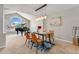 Bright dining room with grand piano, designer lighting, and seating for four at 1774 Brookside Dr, Highlands Ranch, CO 80126