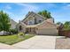 Charming two-story home with a well-manicured lawn, mature trees, and a brick-accented facade at 1774 Brookside Dr, Highlands Ranch, CO 80126
