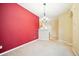 Bright dining room features a red accent wall and chandelier at 9876 W Freiburg Dr # G, Littleton, CO 80127