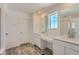 Bright bathroom featuring double vanity sinks, a large mirror, and a glass-enclosed shower at 738 N Clubview St, Watkins, CO 80137