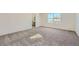 Neutral bedroom with plush carpet, a large window, and a view into the ensuite bathroom at 738 N Clubview St, Watkins, CO 80137