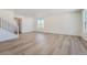 Spacious and well-lit living room showcasing modern wood-style flooring and white walls at 738 N Clubview St, Watkins, CO 80137