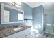 This bathroom features a stylish vanity with granite countertop, modern fixtures, and a glass-enclosed shower at 11886 W 107Th Ave, Westminster, CO 80021