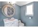 Bathroom features a sink, toilet, and a round decorative mirror at 11886 W 107Th Ave, Westminster, CO 80021