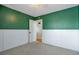 A cozy bedroom with green painted walls, wainscotting, plush carpet and an open doorway at 11886 W 107Th Ave, Westminster, CO 80021