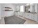 Bright bathroom featuring double vanities, stylish mirrors, and floating shelves for storage at 9228 Lone Timber Ct, Parker, CO 80134