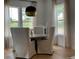 Elegant dining room with a round table, cushioned chairs, a modern light fixture, and large windows at 9228 Lone Timber Ct, Parker, CO 80134