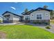Charming home showcasing manicured front lawn, stone accents, and stylish light blue siding, complemented by a beautiful rock garden at 9228 Lone Timber Ct, Parker, CO 80134