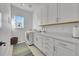Well-lit laundry room with white cabinets, countertop space, and modern appliances at 9228 Lone Timber Ct, Parker, CO 80134