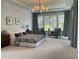 Relaxing main bedroom with tray ceilings, neutral tones, large windows, and a seating area at 9228 Lone Timber Ct, Parker, CO 80134
