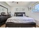 Bedroom with dark-colored bed frame, light-colored bedding, decor and light from the window at 1958 Cathay Ct, Aurora, CO 80011