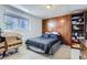 Spare bedroom featuring a bed, wood-paneled wall, and natural light at 1958 Cathay Ct, Aurora, CO 80011