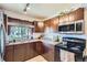 Well-lit kitchen featuring granite countertops, dark cabinetry, and stainless steel microwave at 1958 Cathay Ct, Aurora, CO 80011