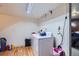A well lit laundry room features wood floors, washer and dryer, and ample space for sorting and folding at 1958 Cathay Ct, Aurora, CO 80011