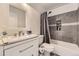 Clean bathroom with white vanity, shower/tub combo with modern gray tile, and built-in shelves at 10767 Appaloosa Ct, Parker, CO 80134