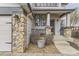 Inviting covered porch with stone pillar accents and professional landscaping at 10767 Appaloosa Ct, Parker, CO 80134