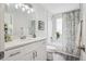 This bathroom features a toilet, shower over tub, white vanity and floral shower curtain at 17634 E Ohio Cir, Aurora, CO 80017