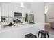 Bright, modern kitchen featuring white cabinets, stainless steel appliances, and a spacious quartz countertop bar at 17634 E Ohio Cir, Aurora, CO 80017