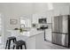Modern kitchen featuring white cabinets, stainless steel appliances, a breakfast bar, and sleek countertops at 17634 E Ohio Cir, Aurora, CO 80017