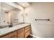 Clean bathroom with single sink vanity with granite countertop and wood cabinets at 7626 Depew St # 102, Arvada, CO 80003