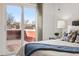 Bedroom featuring sliding glass doors, a warm decorative lamp, and a peaceful deck view at 8424 Everett Way # E, Arvada, CO 80005