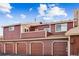 A multi-unit exterior featuring a four-car garage with a red brick facade at 8424 Everett Way # E, Arvada, CO 80005