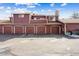 A multi-unit exterior featuring a four-car garage with a red brick facade at 8424 Everett Way # E, Arvada, CO 80005