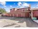 A multi-unit exterior featuring a four-car garage with a red brick facade at 8424 Everett Way # E, Arvada, CO 80005