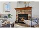 Cozy living space featuring a stone fireplace, comfortable seating, and natural light at 8424 Everett Way # E, Arvada, CO 80005
