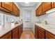 Galley kitchen featuring wood cabinets, white appliances, and laminate countertops with a pass through at 8424 Everett Way # E, Arvada, CO 80005