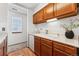 Galley kitchen featuring wood cabinets, white appliances, and laminate countertops, with a window view at 8424 Everett Way # E, Arvada, CO 80005