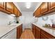 Galley kitchen featuring wood cabinets, white appliances, and laminate countertops at 8424 Everett Way # E, Arvada, CO 80005