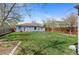 Lovely backyard with green grass, wood fence, and view of the home's exterior at 1740 Trenton St, Denver, CO 80220
