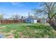 Spacious backyard featuring a storage shed, partial fence, and green grass at 1740 Trenton St, Denver, CO 80220