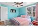 Bright bedroom with blue walls, ceiling fan, and window offering a pleasant outdoor view at 1740 Trenton St, Denver, CO 80220