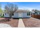 Charming home featuring light blue siding and a well-manicured front yard with mature trees at 1740 Trenton St, Denver, CO 80220