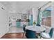 An open-concept dining area and kitchen area features white cabinets and a vintage turquoise refrigerator at 1740 Trenton St, Denver, CO 80220
