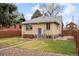 A charming brick home is enhanced with a well-manicured lawn and lush landscaping at 2644 N Glencoe St, Denver, CO 80207