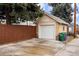 A detached single-car garage with concrete driveway and bordered by a wooden fence at 2644 N Glencoe St, Denver, CO 80207